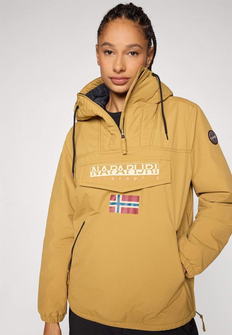 Gelbe Kapuzenjacke mit seitlichen Reißverschlusstaschen, verziert mit einem Logo auf der Vorderseite und einem norwegischen Flaggenpatch. Der Stoff wirkt glatt und wasserabweisend.