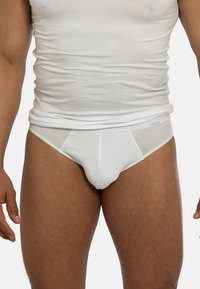 Slip in cotone bianco con una texture liscia e una vestibilità sagomata, caratterizzati da un design classico e senza pattern o accenti visibili.