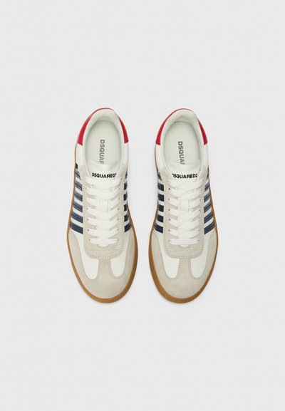Hvide og grå sneakers med marineblå striber, røde detaljer ved hælen og tekstureret ruskind; gummisål; klassisk snørebåndsdesign.