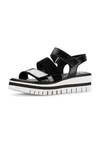 Zwarte platform sandalen met drie verstelbare banden, een soepel leren afwerking en een dikke witte rubberen zool met zwarte strepen en ribbels.
