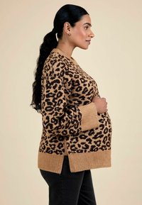 Pull en imprimé léopard en marron et noir, featuring des poignets et un ourlet côtelés, des fentes latérales et une coupe ample, conçu pour le port de maternité.