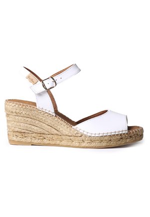 Sandalias de cuña de cuero blanca con tiras en el tobillo, tacón envuelto en yute, punta abierta y detalles de costura en los lados.