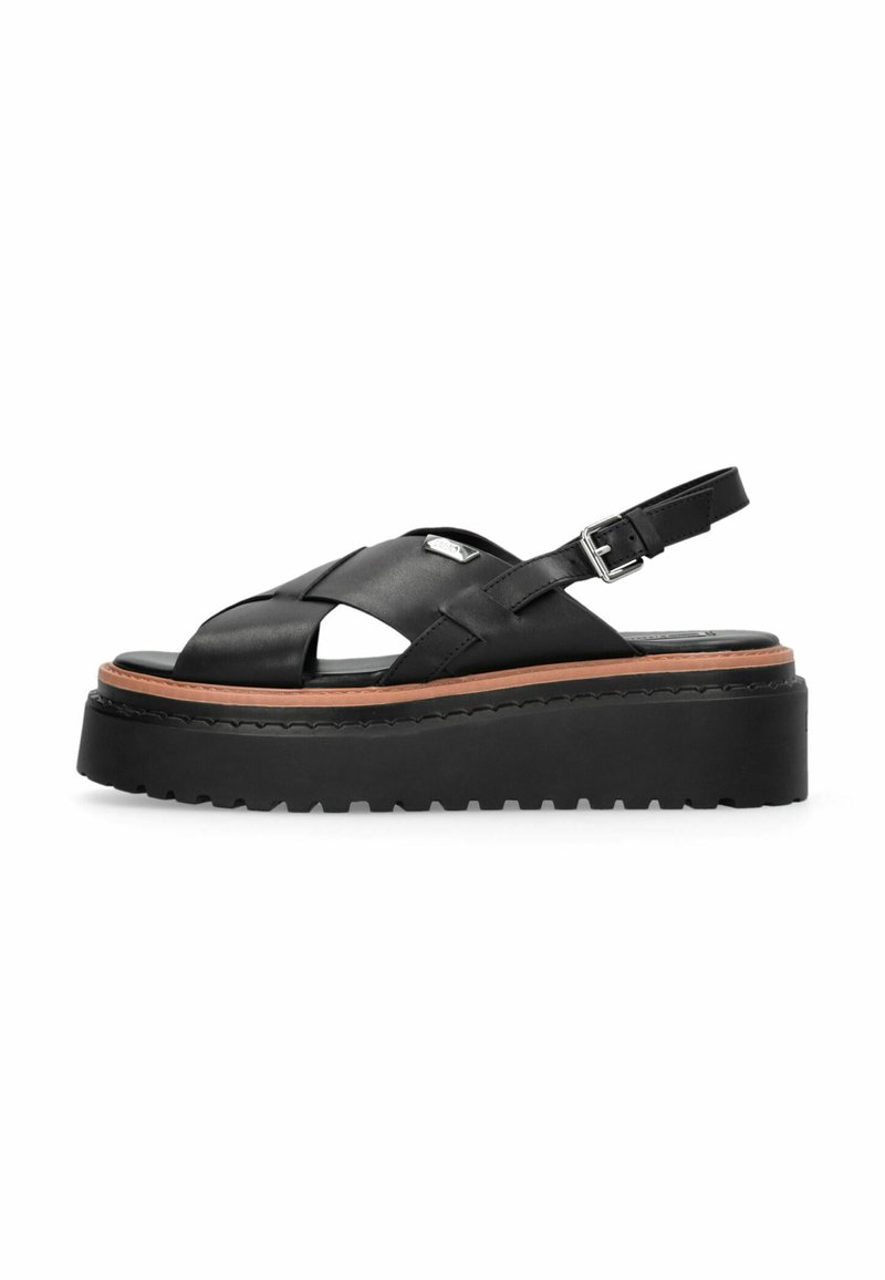 Zwarte leren platformsandalen met een kruislingse bovenkant en verstelbare enkelriem. Voorzien van een dikke rubberen zool en een tan kleurige accent.