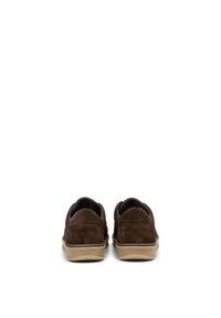 Chaussures slip-on en daim marron avec une semelle beige rembourrée et un bout arrondi, présentant des coutures au niveau du talon et une texture lisse.