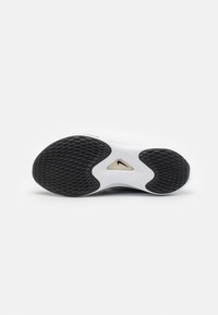 Suela de goma negra con agarre texturizado, entresuela blanca con un recorte y superficie superior lisa. Diseño minimalista con un perfil elegante.