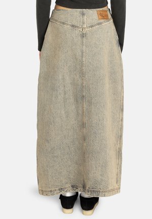 Gonna di jeans con vita alta, colore azzurro chiaro, lunghezza lunga e dettagli di cucitura sul retro. Presenta un'etichetta in pelle marrone in vita.
