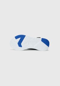 Semelle de chaussure de sport noire avec une base en caoutchouc blanche, présentant un accent bleu en forme de chiffre sept et un motif de relief.
