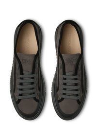Sneaker in suede grigio scuro con suola in gomma nera. Le caratteristiche includono lacci grigi piatti e un marchio impresso sulla linguetta e sulla soletta.