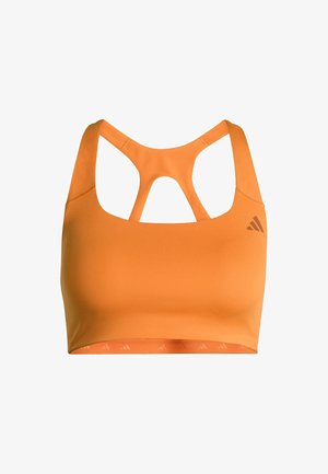 Oranžová sportovní podprsenka s kulatým výstřihem a křížovým designem na zádech. Vyrobena z elastického materiálu, s logem na levé straně.