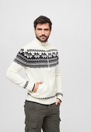 Cremfarbener Strickpullover mit schwarzen geometrischen Mustern. Verfügt über gerippte Bündchen und Saum, einen hohen Kragen und seitliche Taschen.