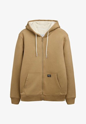 Sweat à capuche beige zippé avec cordons blancs, poches avant kangourou et doublure intérieure en polaire crème douce dans la capuche.