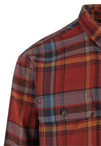 Red and blue plaid flannel shirt with a button pocket, featuring a soft texture, structured collar, and contrasting color patterns.