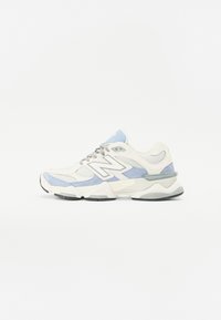 White sneaker with light blue and gray accents. Made of mesh and suede, featuring a thick sole and prominent logo on the side.