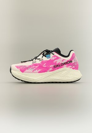 Chaussure de course Salomon blanche et rose avec semelle texturée, lacets noirs et étiquette bleue, vue de droite sur fond neutre.