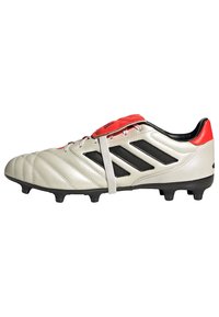 Zapatilla de fútbol gris claro con rayas negras, detalles rojos, parte superior de cuero, superficie texturizada y clavos moldeados para tracción.