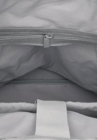 Wnętrze jasnoszarej torby materiałowej z zamknięciem na zamek, z gładką fakturą, wieloma przegródkami oraz mocnym białym paskiem.