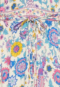 Stoff mit floralem Muster in Creme, versehen mit lebendigen blauen, rosa und gelben Blumen. Beinhaltet einen Taillengürtel mit einem passenden floralen Band.