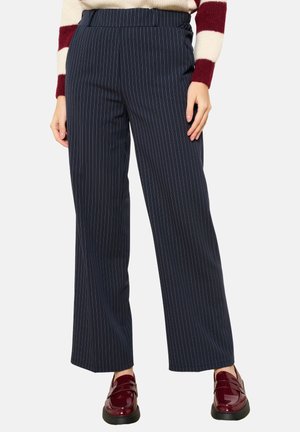 Marine gestreepte wijde broek met een gladde textuur, elastische tailleband en subtiele streepjes. Gecombineerd met glanzende bordeaux loafers.