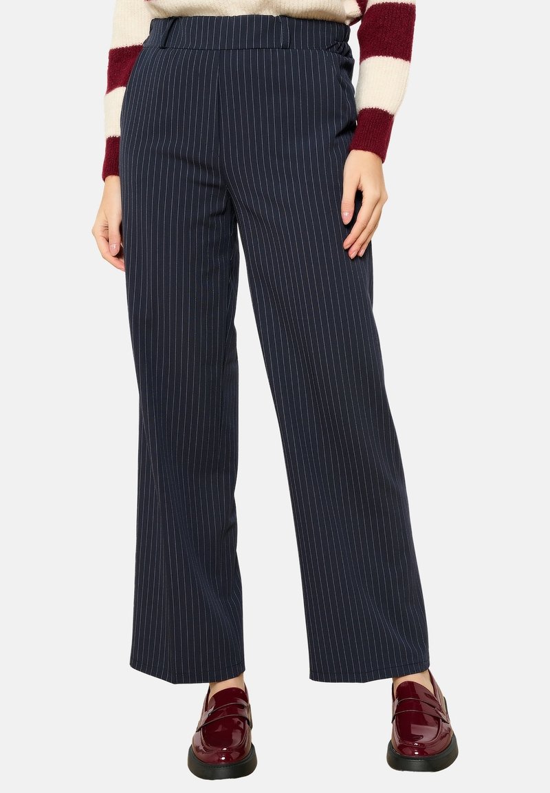 Marine gestreepte wijde broek met een gladde textuur, elastische tailleband en subtiele streepjes. Gecombineerd met glanzende bordeaux loafers.