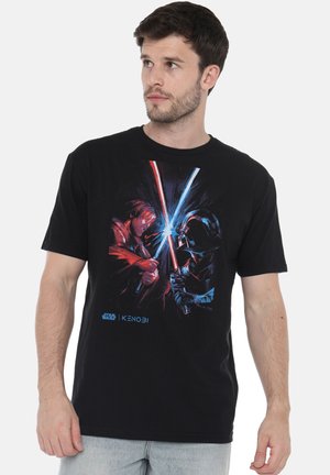 Black cotton T-shirt featuring a graphic print of two characters with red and blue lightsabers clashing, labeled "Star Wars | Kenobi" at the bottom.