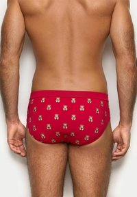Røde herre svømme trusser lavet af strækbart stof, med et gentaget teddy-bear mønster. Glat tekstur med en ensfarvet talje.