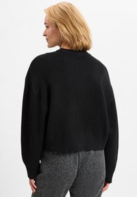 Schwarzer Pullover mit einem verkürzten Design, geripptem Saum und weiten Ärmeln. Weiches Strickmaterial, mit Rundhalsausschnitt und minimalistischer Gestaltung.