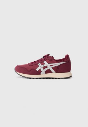 Bordeaux sportieve schoen met een gestructureerde stoffen bovenkant, witte leren accenten, een ronde neus en een lichtgewicht rubberen zool met een profiel voor grip.