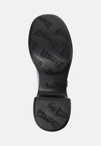 Shoe sole with black rubber tread featuring "CAMPER" branding and size 38 embossed on heel area.