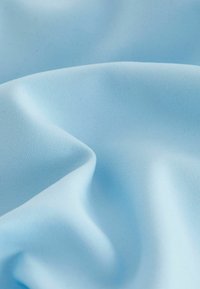 Tessuto azzurro chiaro con una consistenza liscia, che mostra sottili pieghe e grinze, indicando un materiale leggero e flessibile.