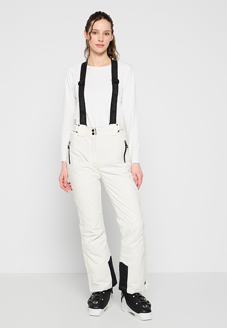 Sneeuwbroeken in een lichtcrème kleur, met verstelbare zwarte bretels, ritszakken en zwarte accenten bij de enkels.