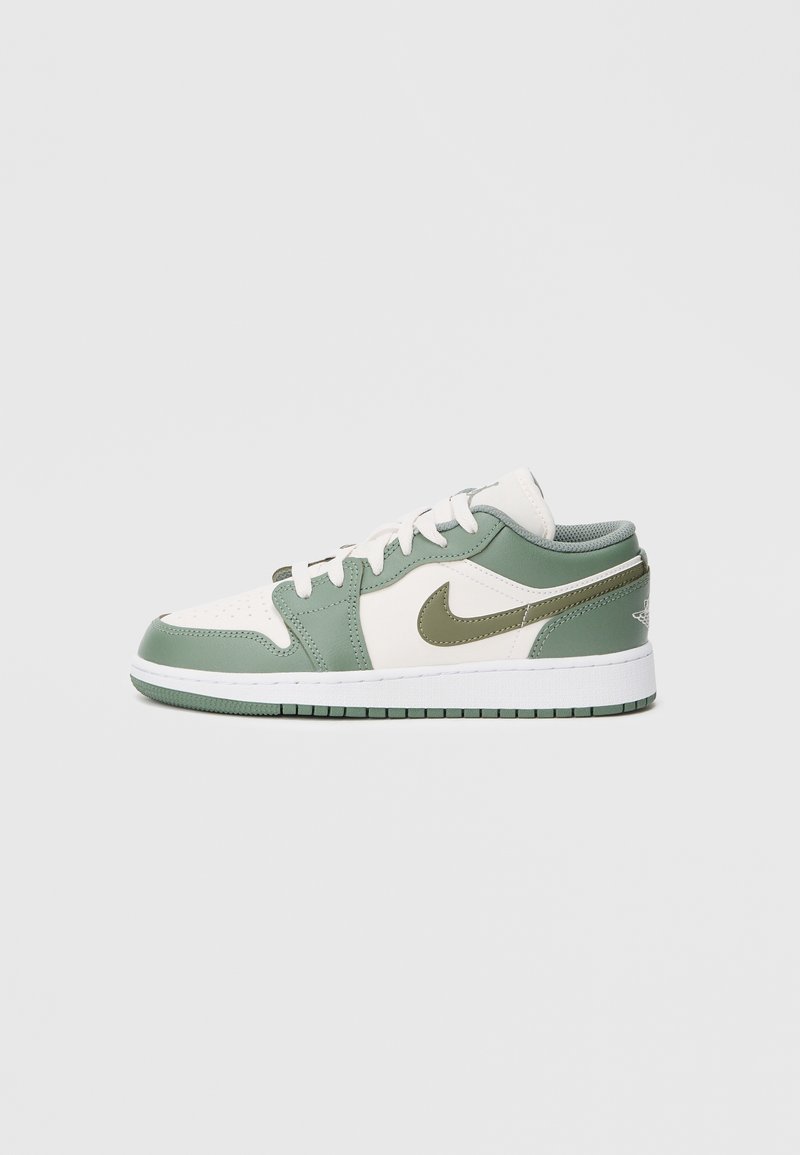 Baskets basses avec des panneaux en cuir blanc et vert atténué, logo Nike vert, lacets blancs et semelle blanche avec motif vert.