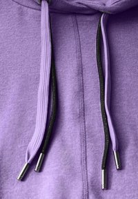 Vaaleanvioletti huppari, jossa on teksturoitu kangas. Varustettu mustilla nyöreillä, joissa on metalliset päädykkeet, ommelluilla saumoilla ja hupulla.