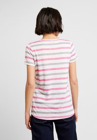 Camiseta de manga corta con rayas horizontales rosas y grises sobre un fondo claro, con un escote redondeado y un pequeño detalle de botón en la parte posterior.