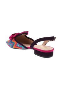 Scarpa piatta multicolore con motivo a zigzag, bordatura in suede viola e accentuata da un fiocchetto. Presenta un tacco basso e un design aperto sul retro.