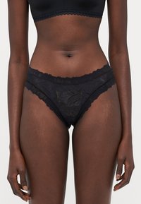 Black lace briefs feature scalloped edges, floral patterns, and a soft, lightweight texture, designed for comfort and a seamless fit.
