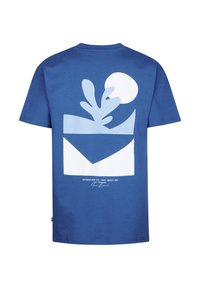 Camiseta de algodón azul con un gráfico blanco de un diseño de planta y sol en la parte trasera, con texto que incluye el nombre de la marca y la ubicación.