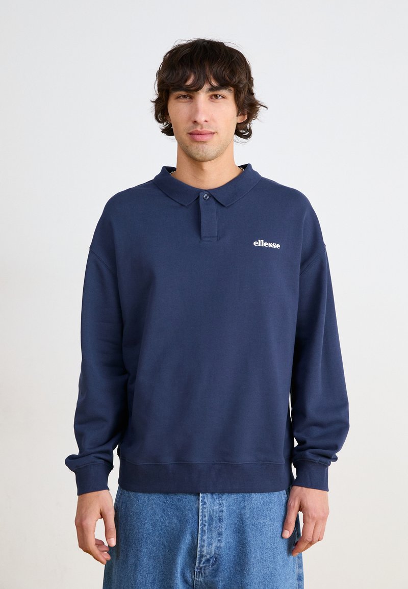 Ναυτικό μπλε φούτερ με γιακά και πλάγια κουμπιά, διαθέτει μικρό λευκό λογότυπο στο στήθος, φτιαγμένο από μαλακό ύφασμα με ριμπ μανσέτες.