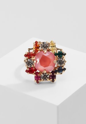 Bague en or avec un grand centre en pierre précieuse rose, entourée de pierres précieuses colorées assorties en rouge, orange, jaune, vert, bleu et transparent.