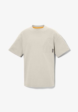 Beżowa bawełniana koszulka z krótkim rękawem, okrągłym dekoltem i kieszonką na piersi z przodu. Posiada kontrastową pomarańczową lamówkę wokół dekoltu.