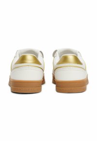 Sneakers bianchi con accenti dorati e suola in gomma beige. Presentano una finitura in pelle liscia e cuciture a contrasto. Nome del marchio inciso sul tallone.