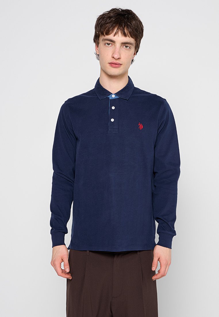 Navy Langarmpolohemd aus weichem Material mit knöpfbarem Kragen, ausgestattet mit einem kontrastierenden blauen Unterkragen und einem kleinen roten Logodetail.