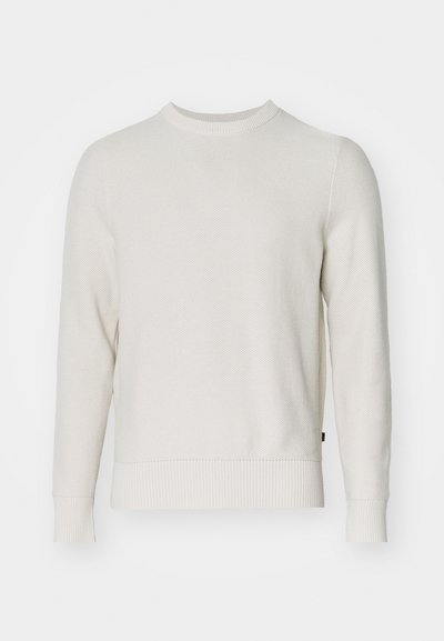 Kermainen neulepaita, jossa on pyöreä pääntie, pitkät hihat sekä ribbineulotut hihansuut ja helma. Tekstuurissa on hunajakenno kuvio.