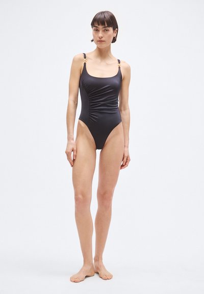 Čierne jednodielne plavky s nastaviteľnými ramienkami, zlatými akcentmi a nariasenou textúrou vpredu. Hladký povrch látky.