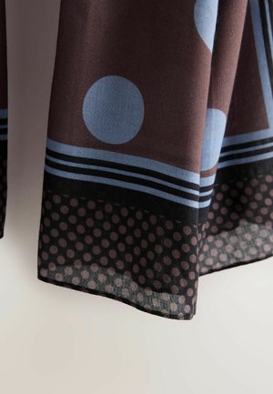 Brown fabric with large blue circles and striped patterns. Hem features a sheer section with black polka dots. Soft texture.
