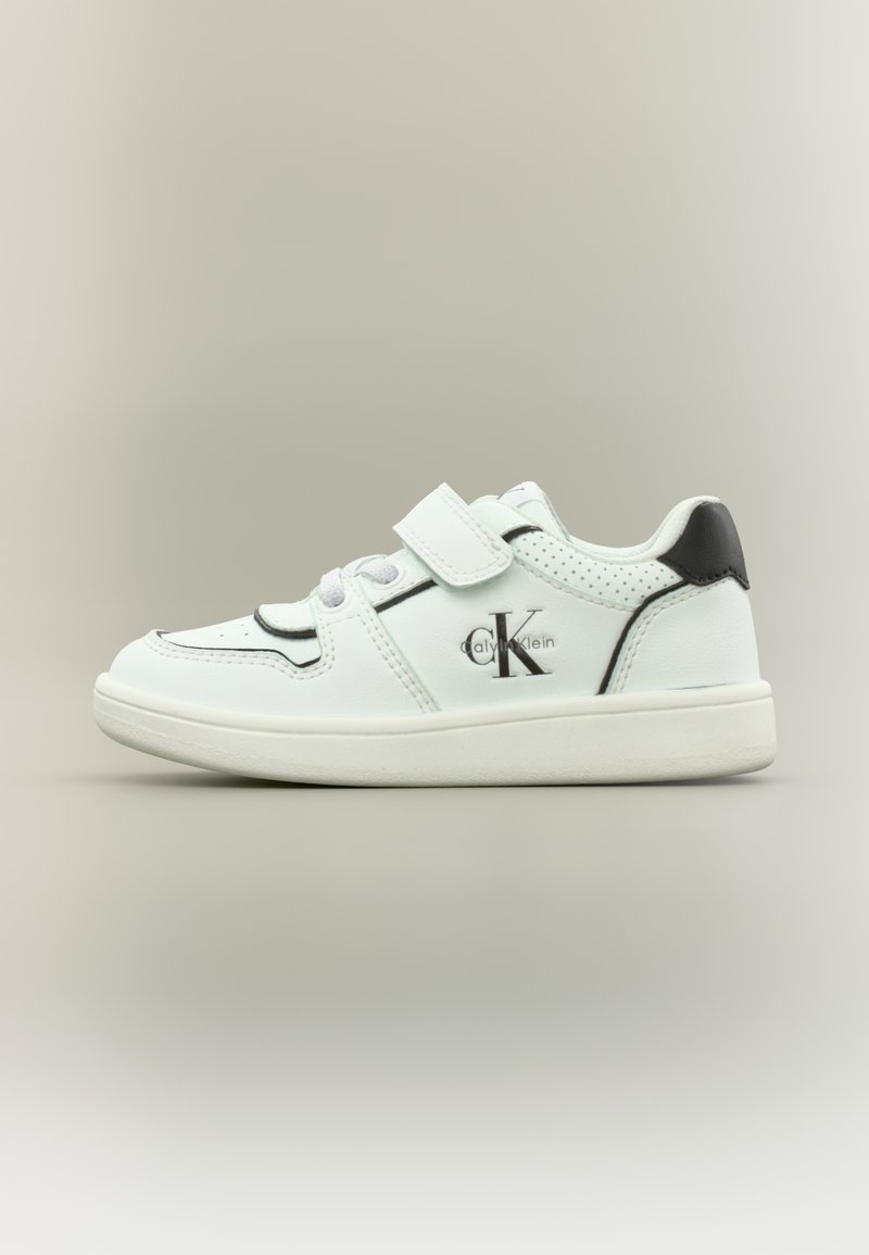 Weißer Sneaker für Kinder aus Leder mit schwarzem Fersenakzent, rundem Zehenbereich, perforierten Seiten, elastischen Schnürsenkeln und verstellbarem Klettverschluss.