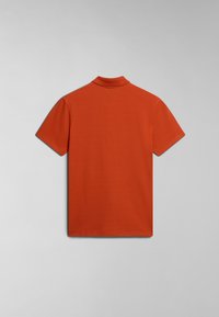 Koszulka polo z krótkim rękawem, wykonana z jednolitej bawełny w kolorze pomarańczowym. Posiada klasyczny kołnierzyk oraz gładką, równą fakturę. Brak widocznych wzorów lub detali metalowych.