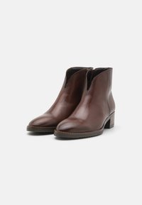 Brune lær ankle boots med rund tå, elastiske sidesider og en lav blokkheel. Glatt tekstur med minimale sømdetaljer.