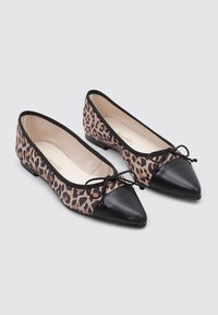 Las bailarinas de estampado de leopardo cuentan con una punta afilada de cuero negro y lazadas, con un interior suave y una textura exterior sutil.