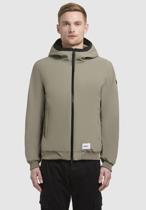 Kapuzensweatjacke in olivgrün, mit einem Vorderreißverschluss, Seitentaschen, elastischen Bündchen und einem Logo-Patch auf der Vorderseite. Glattes, wasserabweisendes Material.