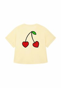 T-shirt oversize gialla con una grafica di due cuori rosse collegate da un gambo nero e una foglia verde sul retro.